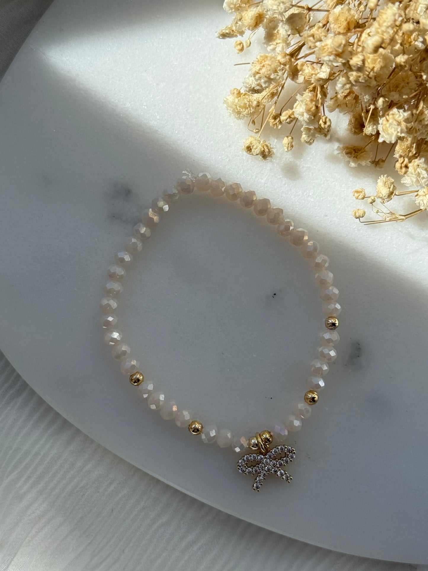 Perlenarmband mit Beigen Kristallperlen, Goldenen Perlen + Schleifen Anhänger - 2263